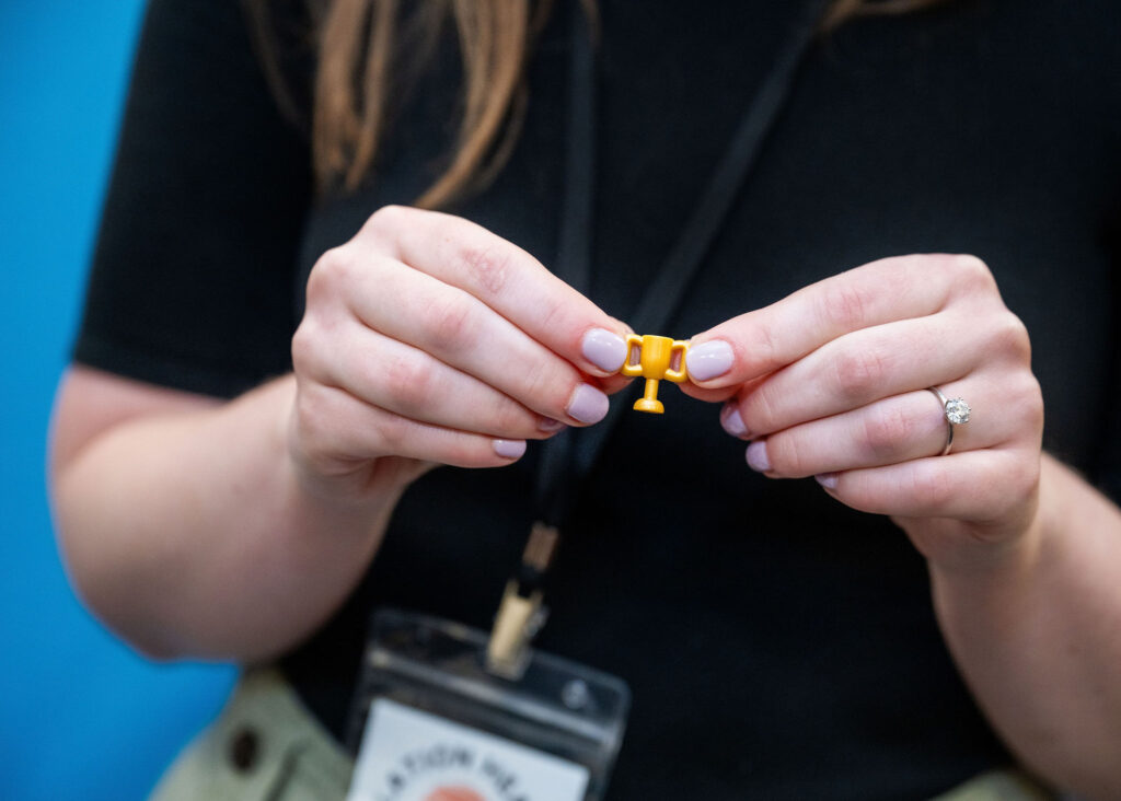 Person holding tiny trophy with hands