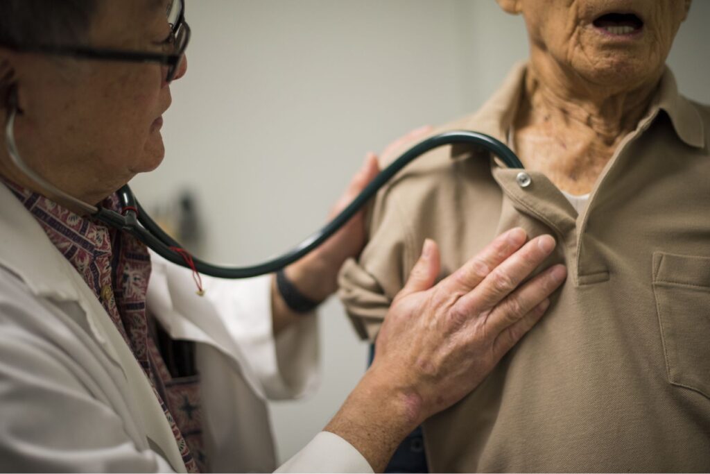 Doctor using stethoscope on patient