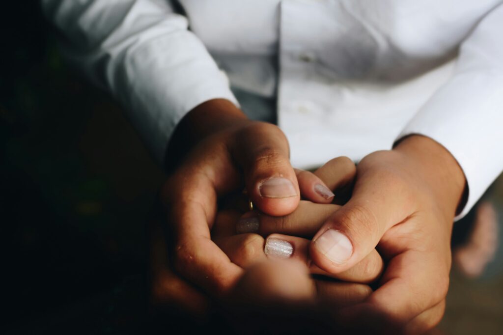 zoomed-in photo of parent holding child's hands