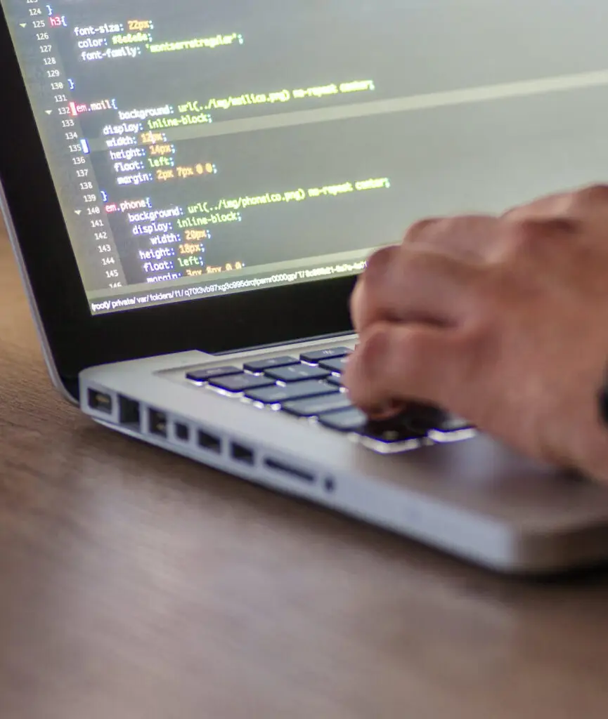 Developer's hands typing on laptop