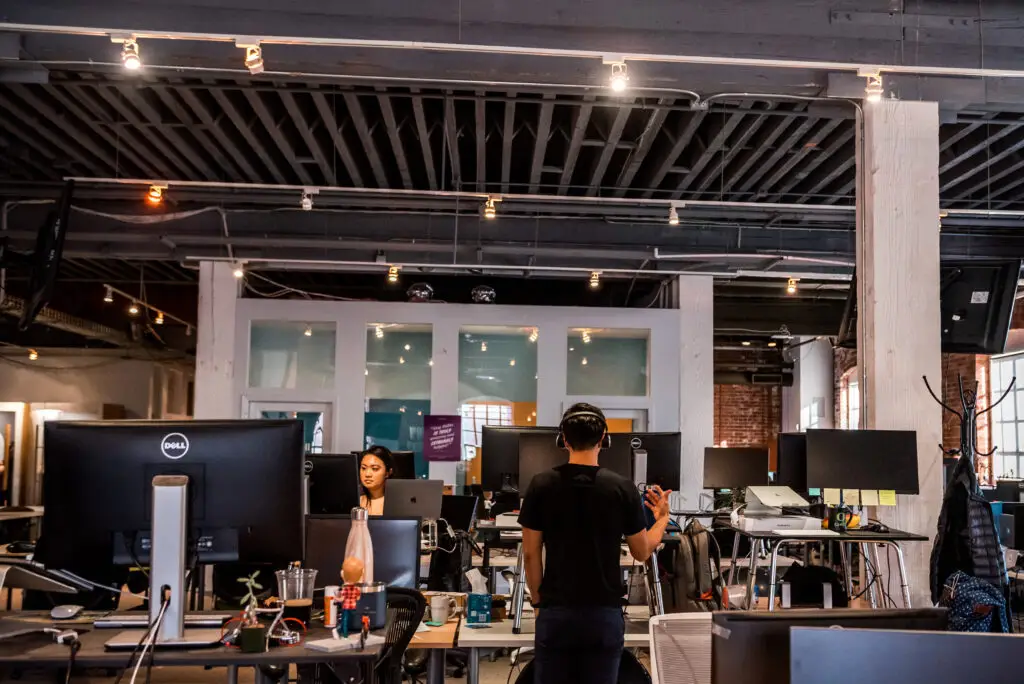 tech workers working at standing desks in industrial office space